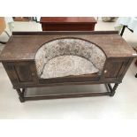 An oak upholstered seat settle/cupboard and yew style drawered hall table