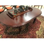 A Victorian mahogany wind-out dining table on bulbous legs and castors with one extra leaf