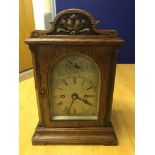 An oak cased striking mantel clock