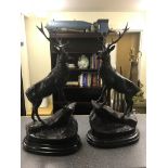 A pair of bronze stags on marble bases