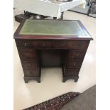 A reproduction mahogany leather-topped knee-hole desk