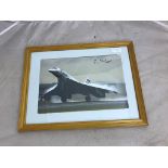 A framed photograph of Concord taking off, signed by Captain Neil Briton,