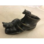 A bronze boot with cat and mouse,