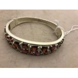 A silver abstract bangle set with garnets