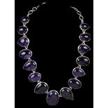 A Silver Abstract Amethyst Necklace: Comprising 15 alternating graduated oval and pendaluque cut