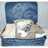 A suitcase containing wool jumpers and others