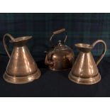 A copper kettle and two copper jugs