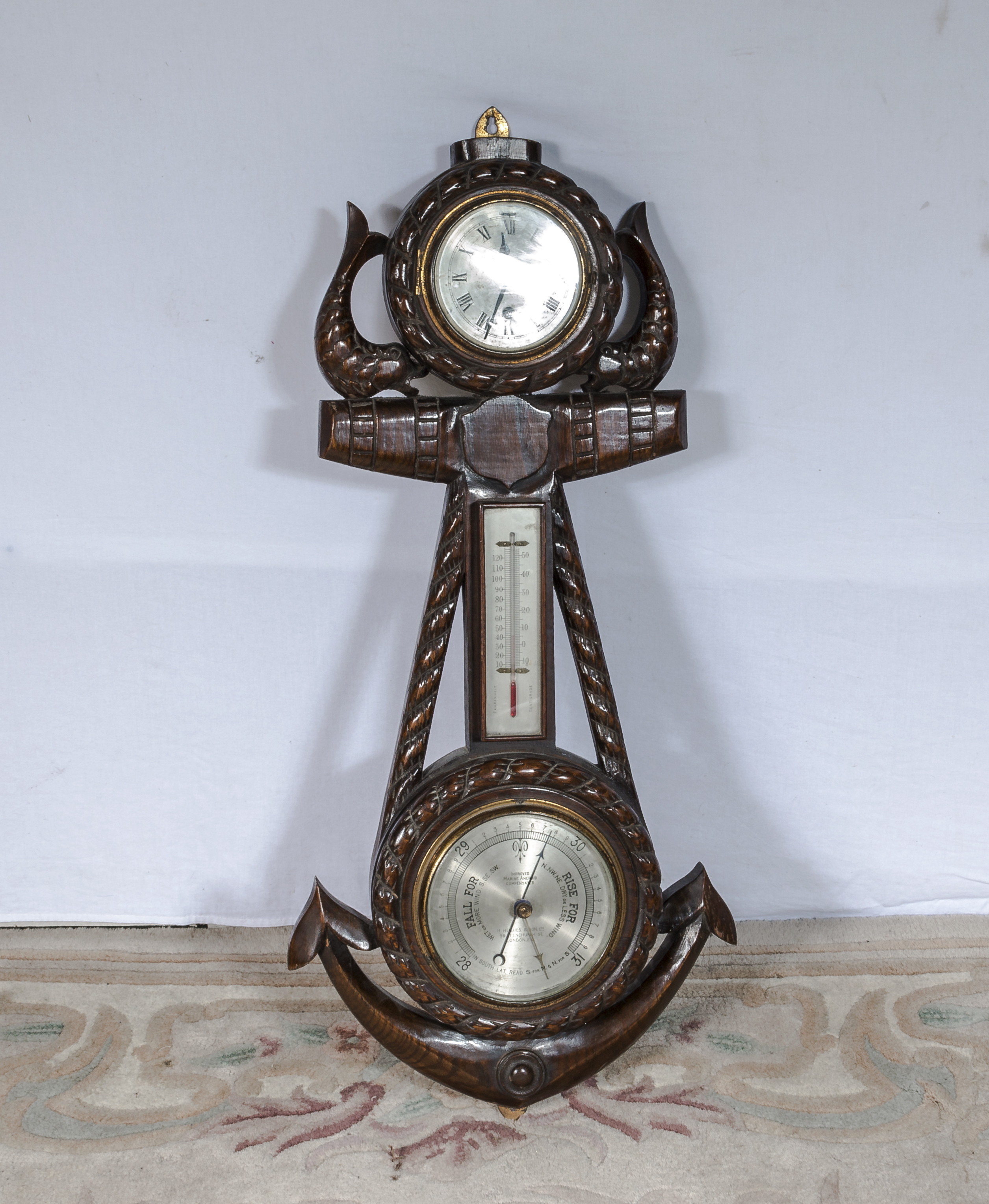 A very nice carved oak clock barometer depicting dolphins and anchor. 85cm tall