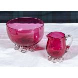 A cranberry glass sugar bowl and cream jug