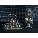 A silver plated and glass coffee carafe warmer together with a silver plated tea service and tray