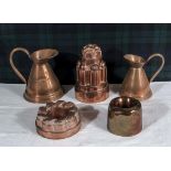 Three copper jelly moulds and two copper jugs