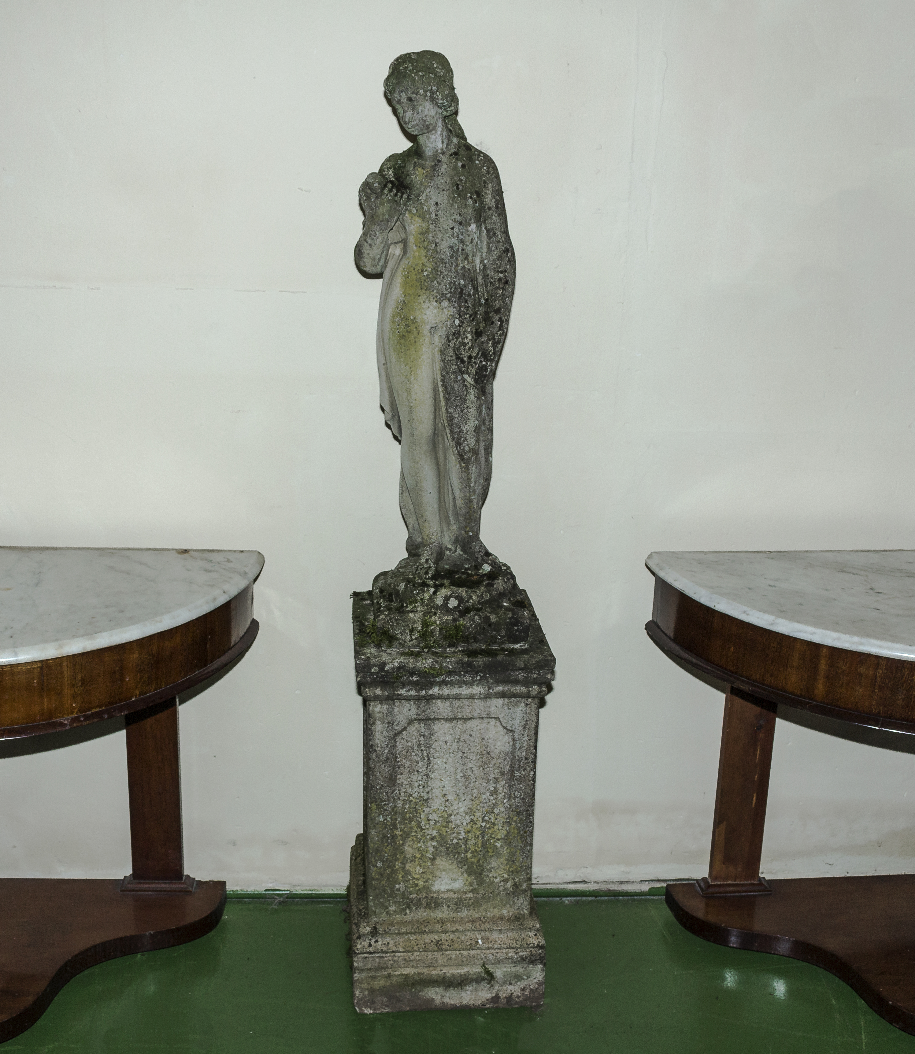 A reconstituted stone figure of a lady on a plinth