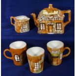 A cottage ware teapot, milk jug and three mugs