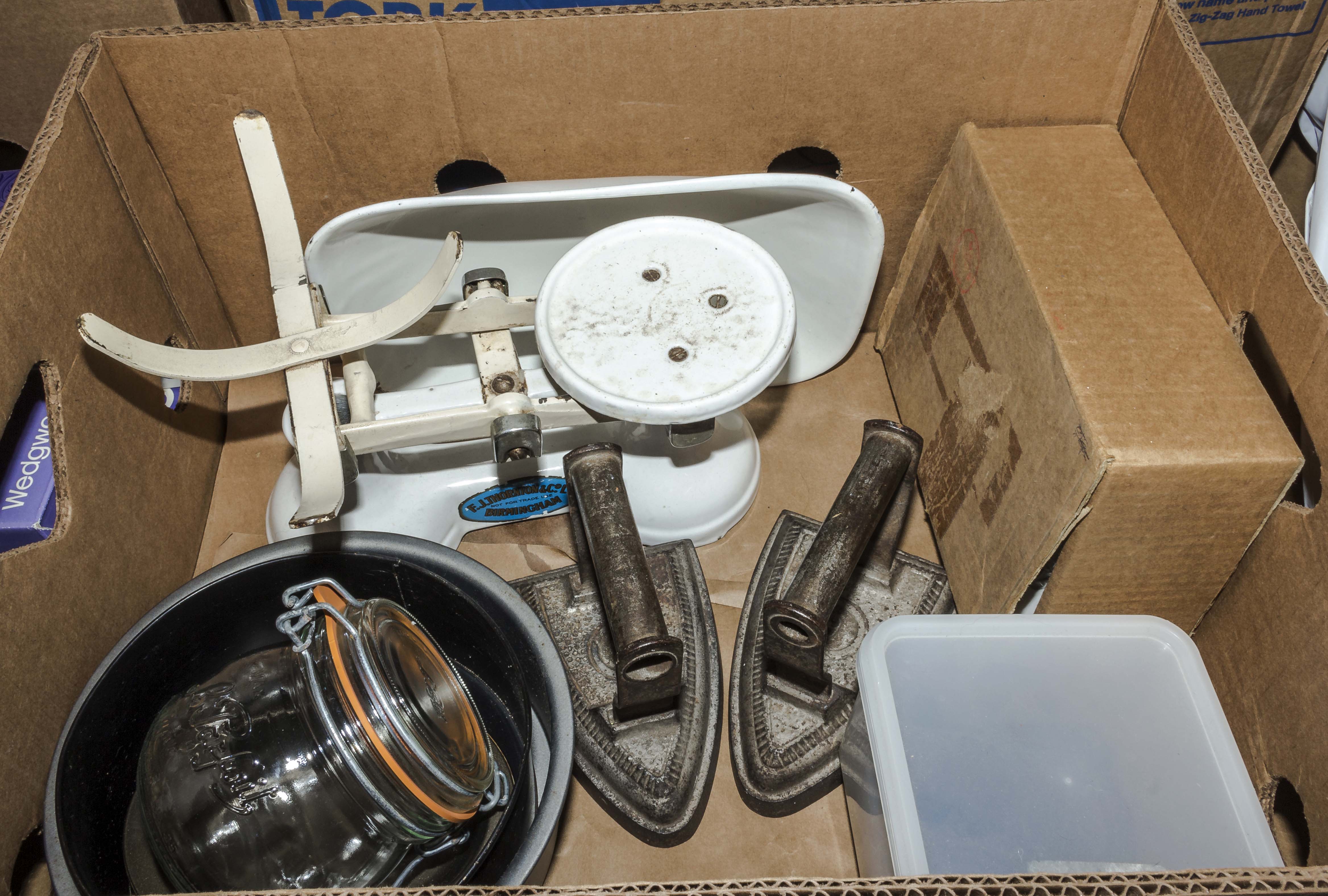 A box containing scales, irons and other items