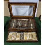 A complete set of antique opticians eye testing equipment in mahogany glazed case, including