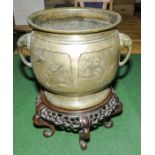 A Chinese bronze urn on hardwood stand.