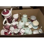 A box containing a coffee set and assorted teacups and coffee cans