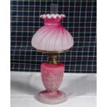 A pink satin glass lamp with shade.