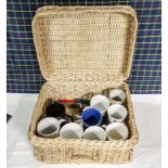 A picnic basket containing mugs
