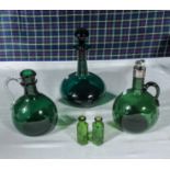 Three green glass decanters and two small poison bottles