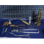 A collection of veterinary instruments and a brass microscope