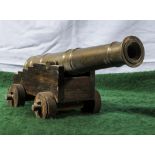 A small brass cannon on wooden stand