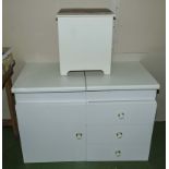 A white cupboard and drawer unit together with a laundry box