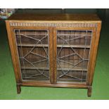 A small oak display cabinet with leaded glass doors.