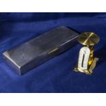 A cigarette box and a small brass scale