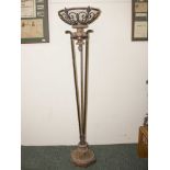 An American uplighter floor lamp consisting of stone base and light holder wrought iron and glass