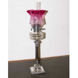 A Georgian hall marked silver Corinthian column oil lamp with cranberry glass shade