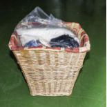 A laundry basket containing cushion and fabrics