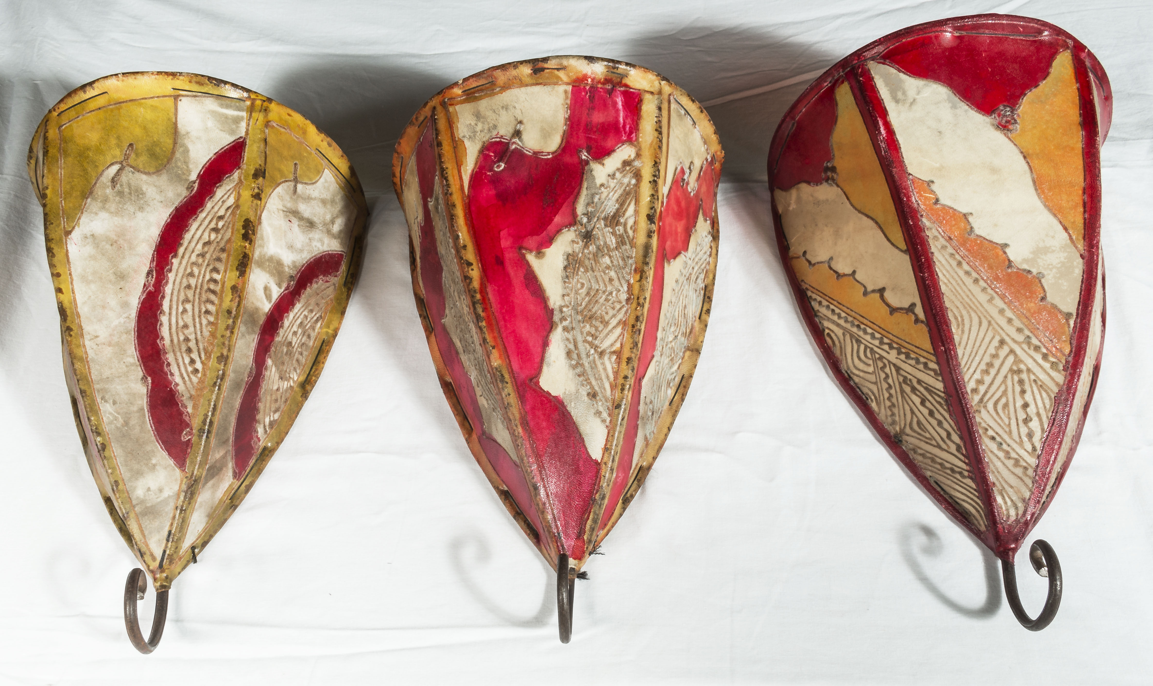 A set of three hand painted vellum light shades in the manner of Bugatti, 33cm x 23cm