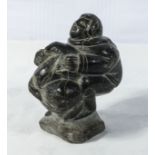 Antique Inuit soapstone carving of an Eskimo holding a sea lion. 15cm tall