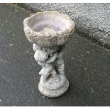 A reconstituted stone bird bath