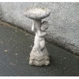 A reconstituted stone bird bath