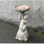 A reconstituted stone bird bath