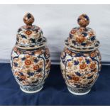 A pair of antique Imari dome shaped lidded vases, 30cm tall