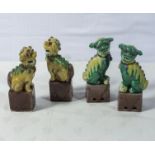 Two pairs of small antique Chinese temple dogs decorated on famille verte coloured enamels, 15cm and