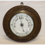 A small carved wood barometer