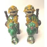 A pair of Chinese pottery Sancai table lamps in the form of seated dogs of foe on rectangular plinth