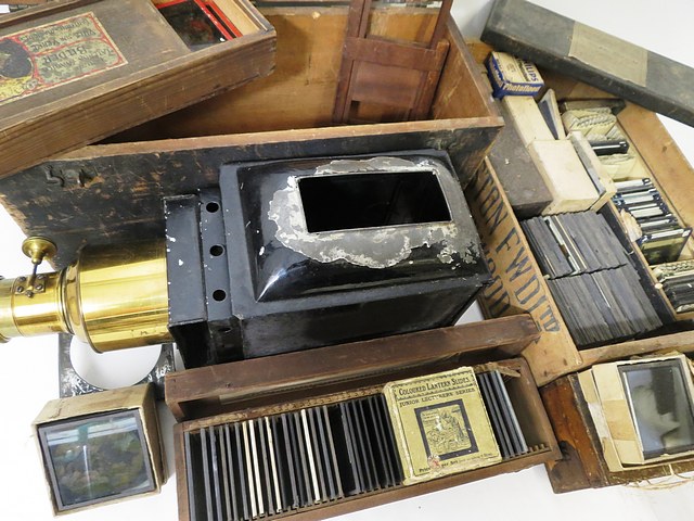 An early 20th century magic lantern with brass lens and wooden box, interior of lid with factory - Image 2 of 2