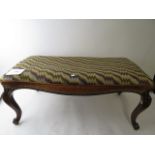 A late Victorian rosewood duet stool having a serpentine shaped frame on cabriole legs with scroll