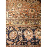 An early 20th century Persian Kashan carpet, hand woven, red and blue ground, flora and