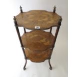 A French three tier inlaid étagère with gilt brass finials and shelf edges, on splayed hoof feet,