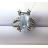 An 18ct white gold aquamarine and diamond set ring, the central baguette cut aquamarine claw set