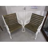 A pair of white enamelled cast alloy garden seats with mask and scrolled ornament