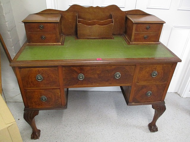 An early 20th century walnut desk, 48 h, 43 w, 20 d, with green leather scriber below an inset