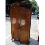 A 1930s walnut and mahogany wardrobe with twin panelled doors, raised on stubby cabriole feet, 73