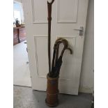 An elm stick stand, together with a quantity of canes, walking sticks and a vintage umbrella